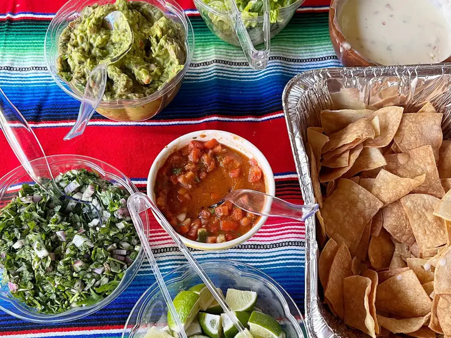 Catering spread from the Avocado Pit, including tortilla chips, salsa, and guacamole.