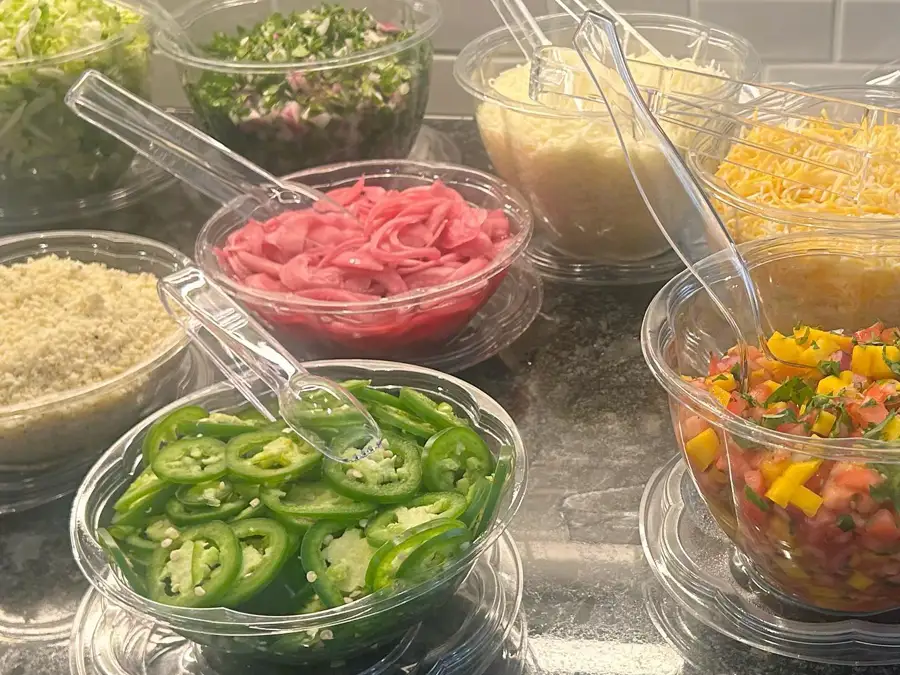 Catering side dishes, including jalapenos, cheese, and salsa from the Avocado Pit. 