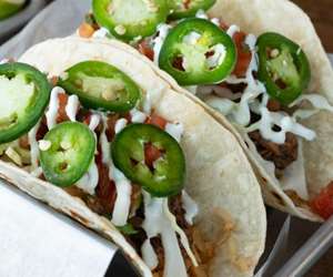 Two tacos topped with jalapenos.